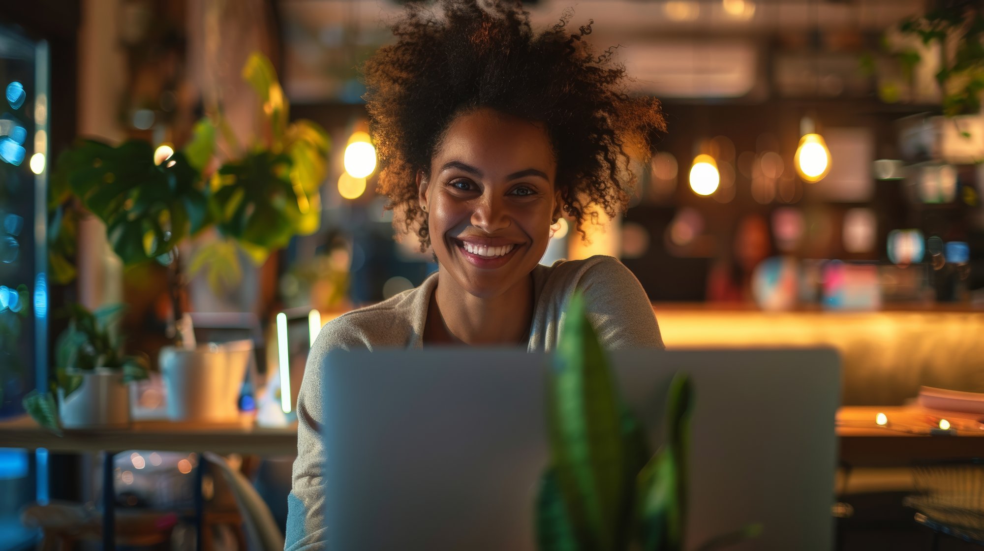 professional-woman-smiling-laptop-screen-communal-workspace-soft-lighting (1)